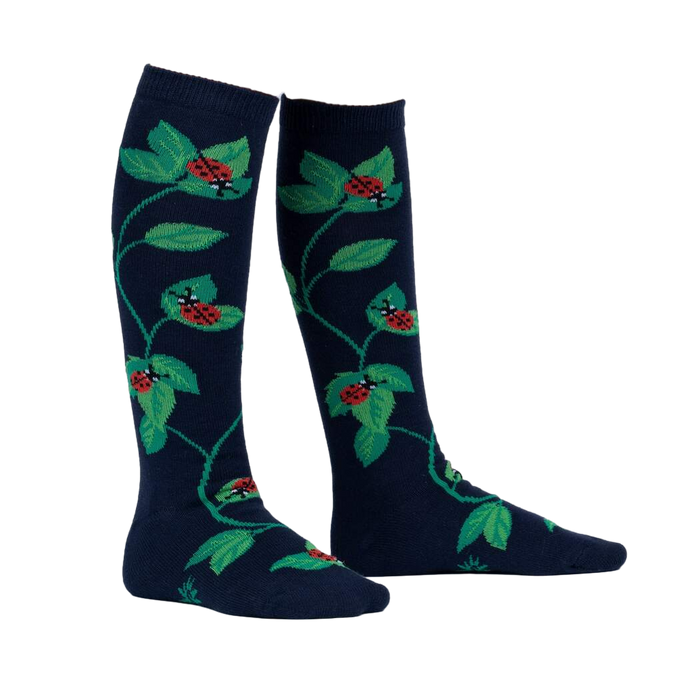 Close-up of 'Luck Be a Lady Bug' socks on a person's legs, showcasing the design and fit.