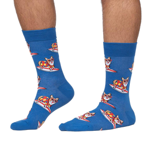 Lifestyle shot: Person wearing blue crew socks with a pattern of corgis surfing.