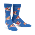 Pair of blue crew socks with repeating pattern of corgis wearing colorful shirts and surfing. 