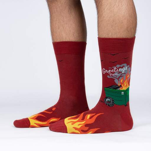 A pair of red socks with a picture of a burning dumpster on them. The text on the socks says 