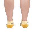 Rear view of a person wearing the bee socks against a white background.