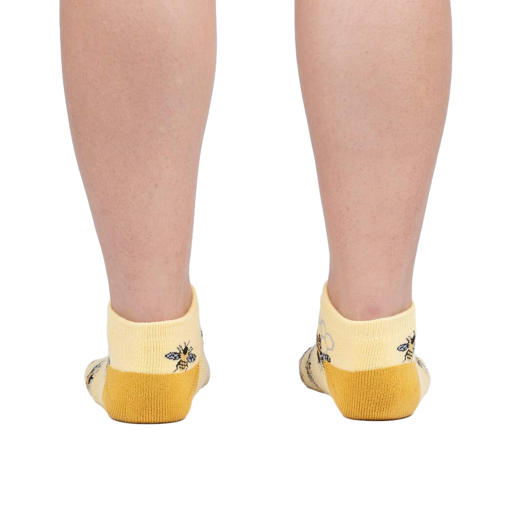 Rear view of a person wearing the bee socks against a white background.
