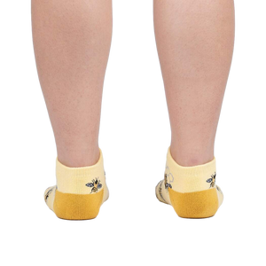 Rear view of a person wearing the bee socks against a white background.