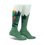 Knee-high socks in green and light green featuring a cartoon bear wearing sunglasses in a forest scene.  The words 'That's Shady' are on the sock.