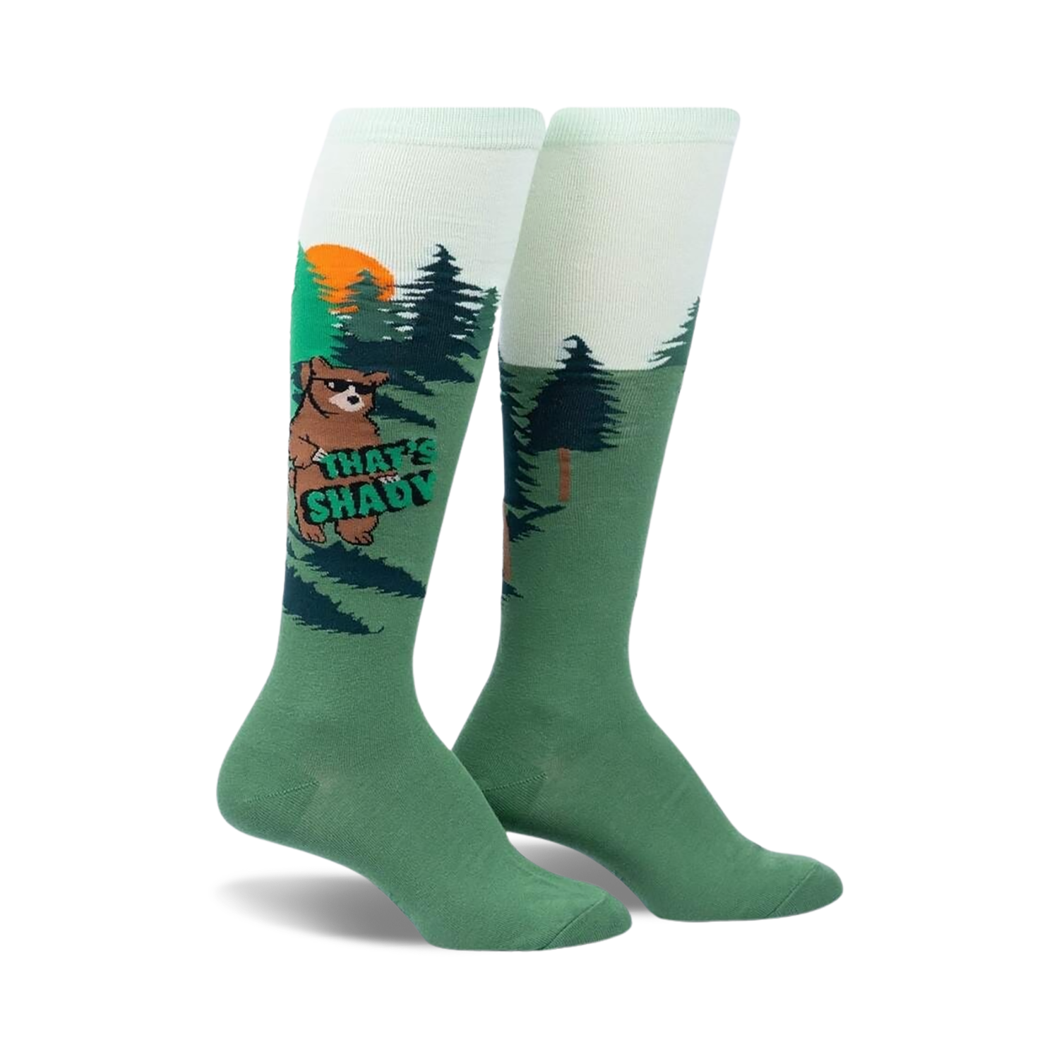 Knee-high socks in green and light green featuring a cartoon bear wearing sunglasses in a forest scene.  The words 'That's Shady' are on the sock.