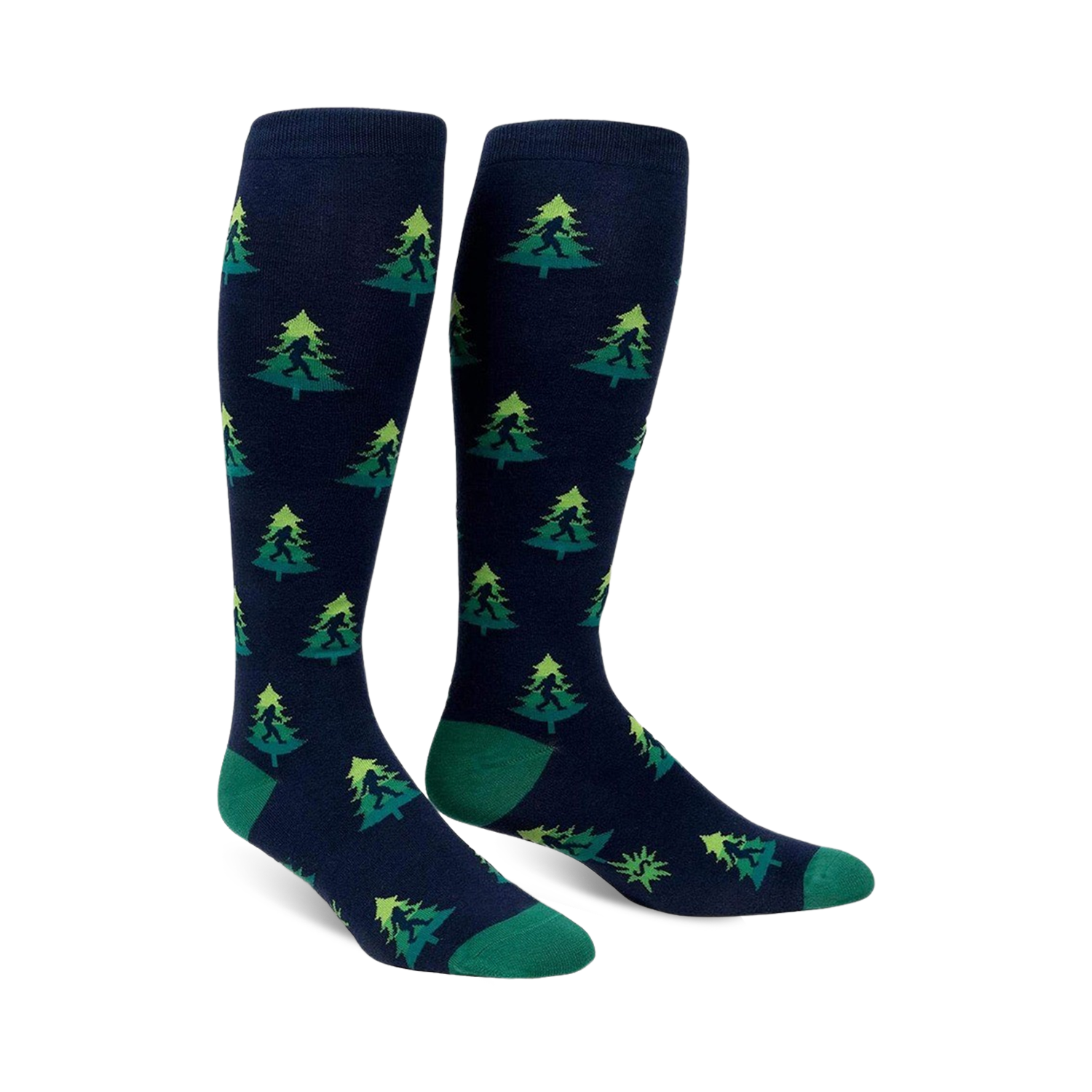 Pair of navy blue knee-high socks with a repeating pattern of green Bigfoot figures hidden amongst lime green and darker green Christmas trees.