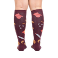 Back view of 'Bake at 350' burgundy knee-high socks on a person's legs against a white background.