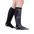 Lifestyle shot: A person's legs wearing the black knee-high musical note socks.