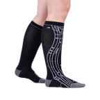 Lifestyle shot: A person's legs wearing the black knee-high musical note socks.