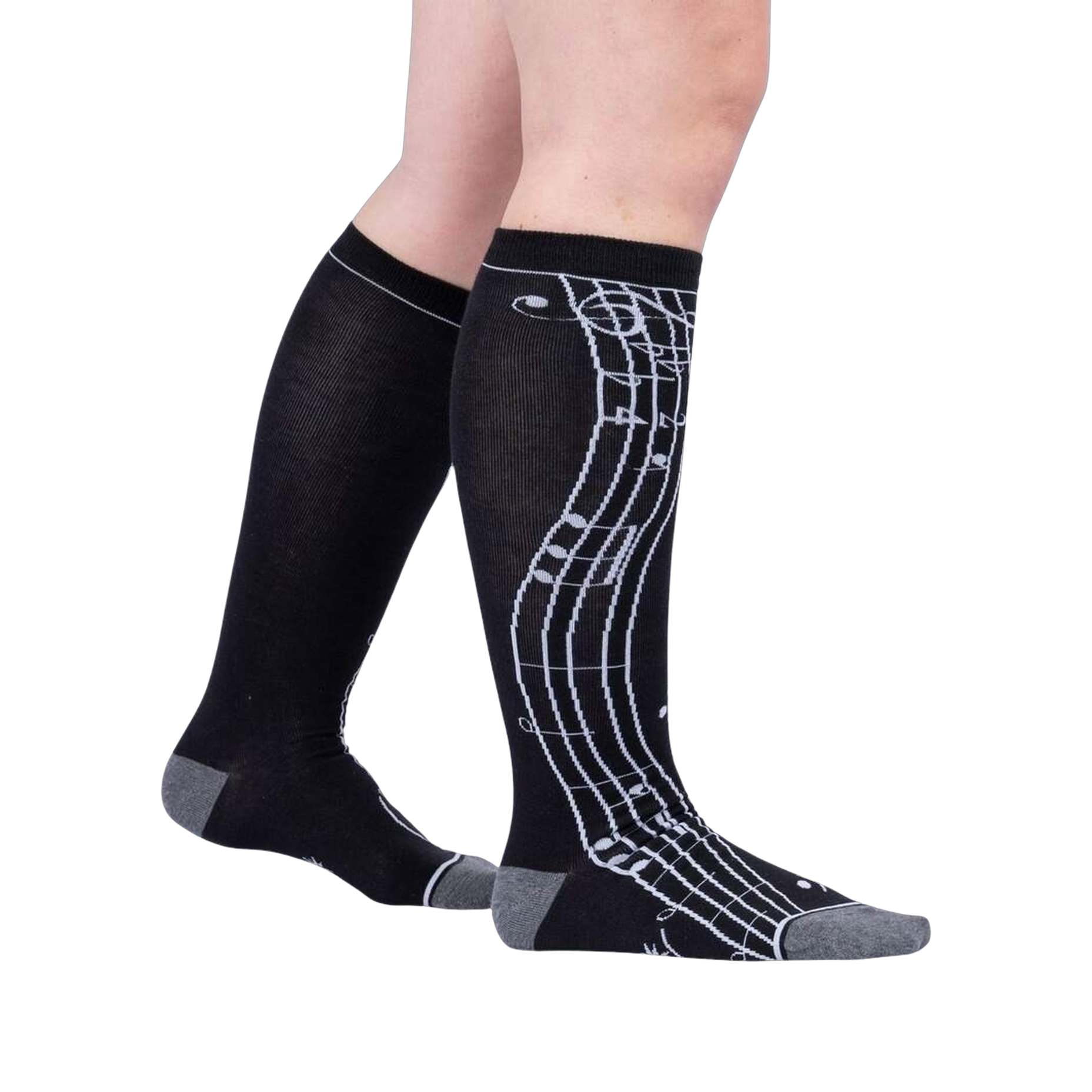Lifestyle shot: A person's legs wearing the black knee-high musical note socks.