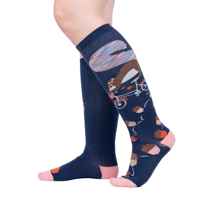 Lifestyle shot showing the 'Feeling Squirrelly' knee-high socks on a person's legs against a light gray background.
