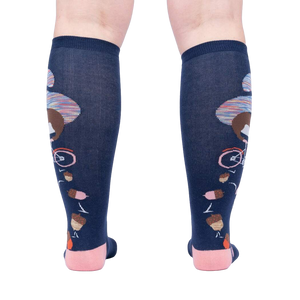Rear view of the 'Feeling Squirrelly' knee-high socks on a person's legs, highlighting the full design on both socks.
