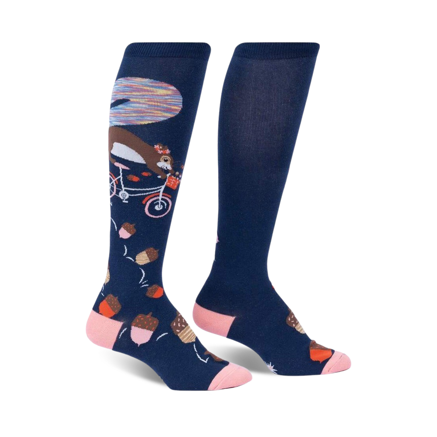 Pair of navy blue knee-high socks with a whimsical design: a squirrel riding a bicycle amidst acorns and a colorful background detail.