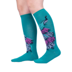 Lifestyle shot showcasing 'A Fan-tastic Tail' knee-high socks on a model's legs against a light gray background.