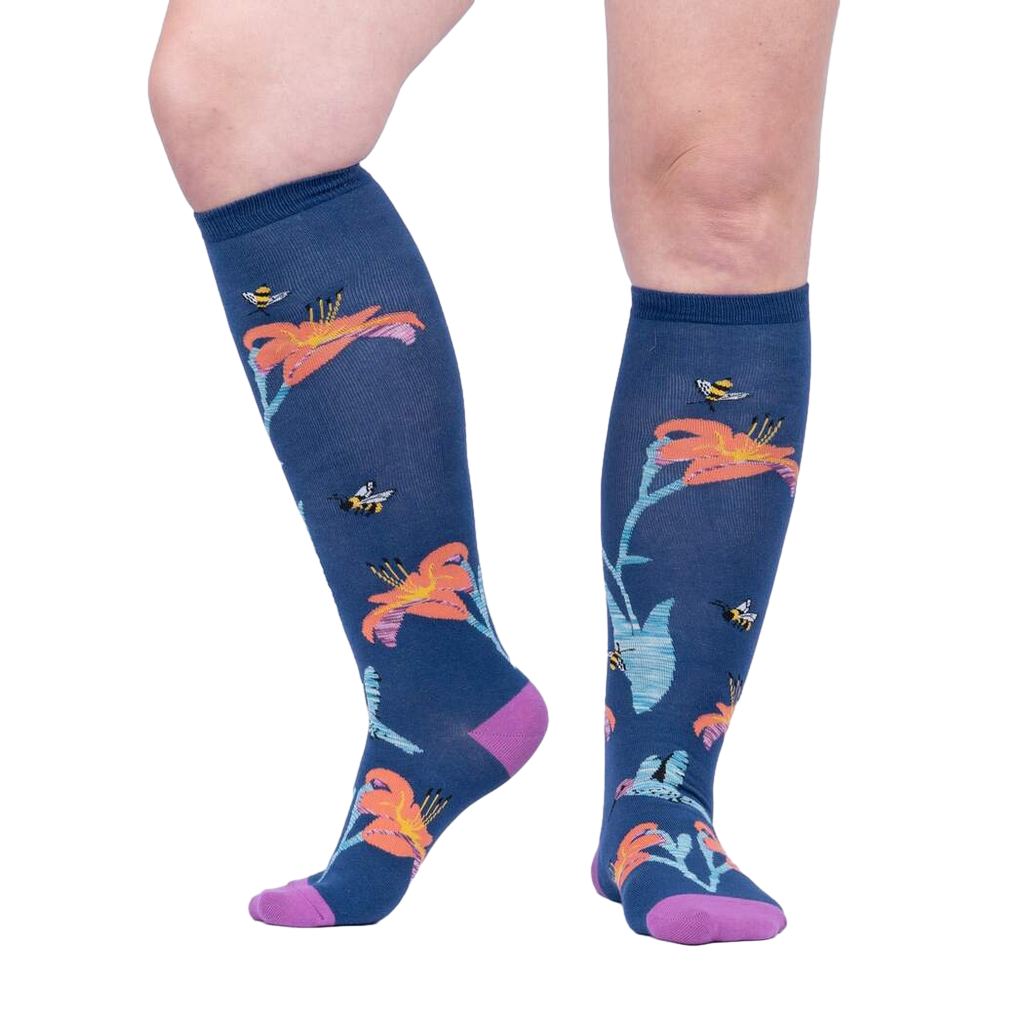 Lifestyle shot: A person's legs wearing the Hmmmmmingbird knee-high socks, showcasing the design and fit.