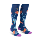 Pair of knee-high socks in navy blue.  Features a whimsical design of orange lilies, hummingbirds, and bees.