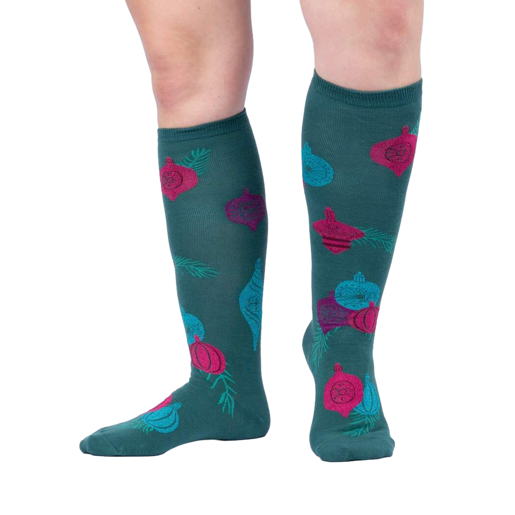 Lifestyle shot showing 'Bring the Bling' knee-high socks on a person's legs against a light grey background.
