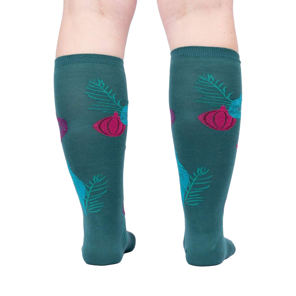 Rear view of 'Bring the Bling' knee-high socks on a person's legs against a light grey background.