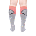 Rear view of a pair of grey and coral knee-high socks with an elephant and bubble design.