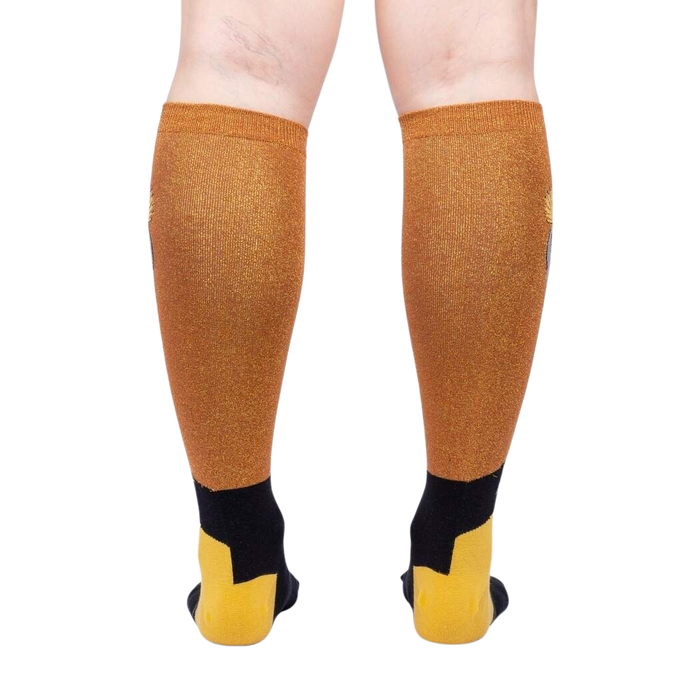 A pair of gold and black knee-high socks with a geometric pattern displayed on the back of the leg.