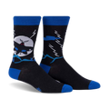 Crew socks in black and blue, featuring a Mothman design against a moonlit, mountainous scene.  They glow in the dark!