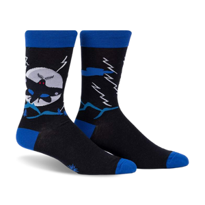 front view of a pair of black socks with blue and white details. the socks have a graphic of a bat flying in front of a moon, mountains, and lightning.