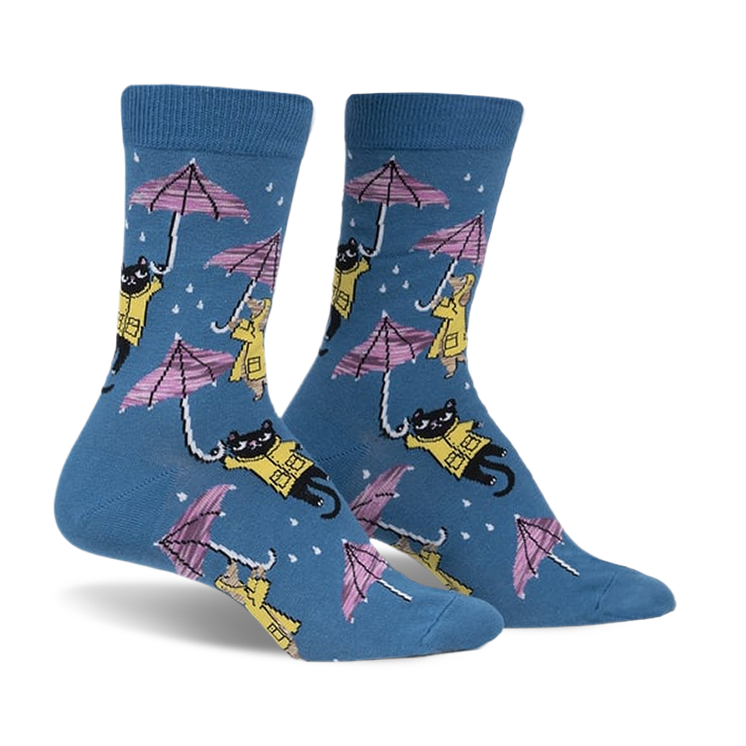 Pair of blue crew socks with a repeating pattern of black cats and dogs in yellow raincoats holding pink umbrellas in the rain.