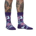 Lifestyle shot of a model wearing the Fin Friends socks, showcasing the socks' fit and pattern on legs with tattoos.
