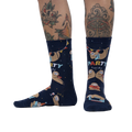 Lifestyle photo showing the socks on a person's legs, showcasing the sock's fit and design on a model with tattoos.