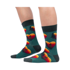 Lifestyle shot showing the socks on a person's legs; teal socks with Sasquatch and sunset heart design.