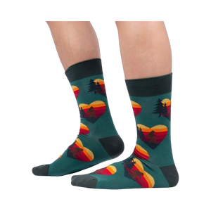 Lifestyle shot showing the socks on a person's legs; teal socks with Sasquatch and sunset heart design.