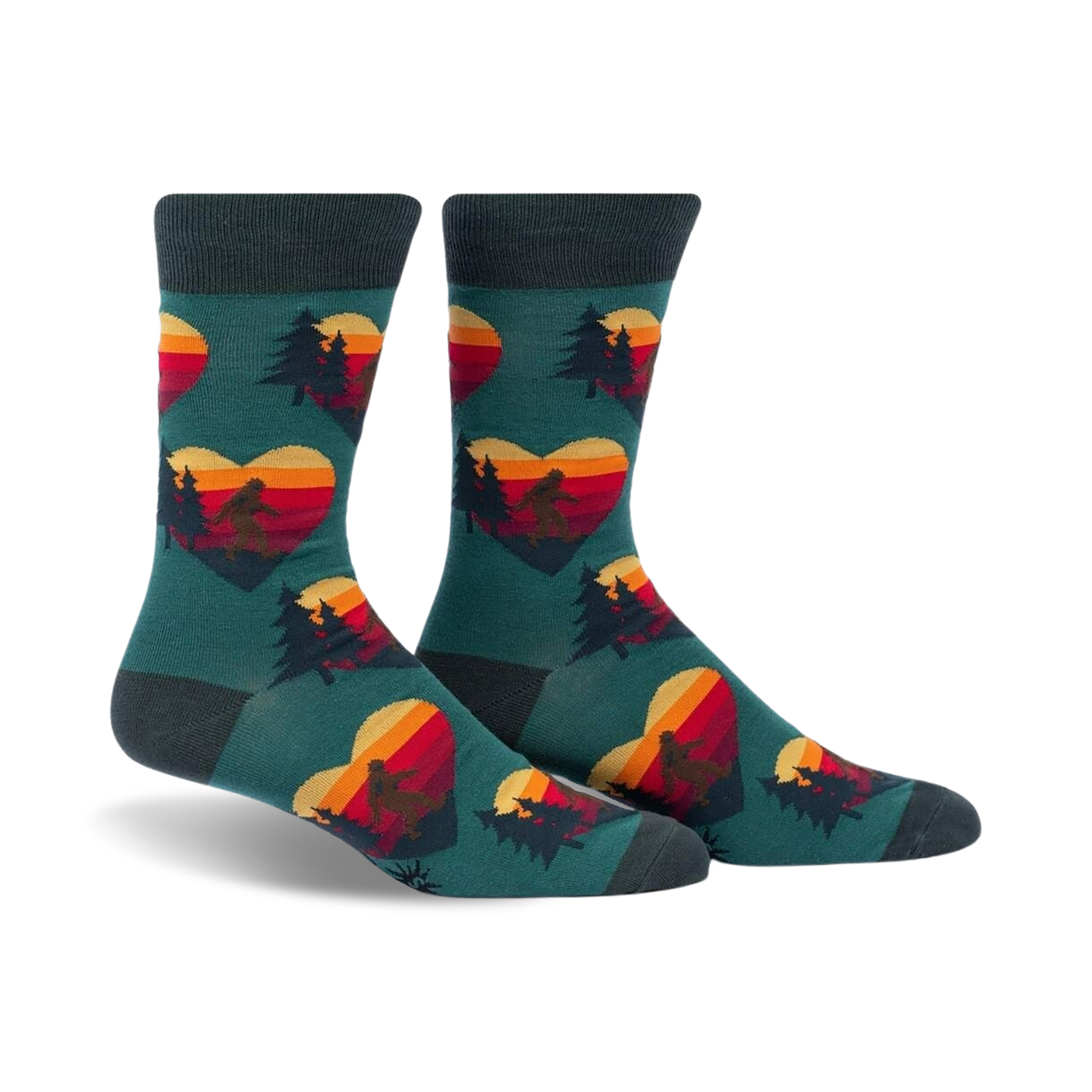 Crew socks in teal with a repeating pattern of retro sunset hearts featuring Sasquatch silhouettes and pine trees.