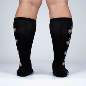 A pair of black knee-high socks with a pattern of multi-colored unicycles.