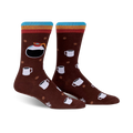 A pair of brown crew socks with a colorful stripe at the top. The socks feature a design of coffee pots, mugs, and coffee beans.
