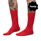 Close-up on a person's legs wearing red crew socks with maroon fuzzy hearts. 