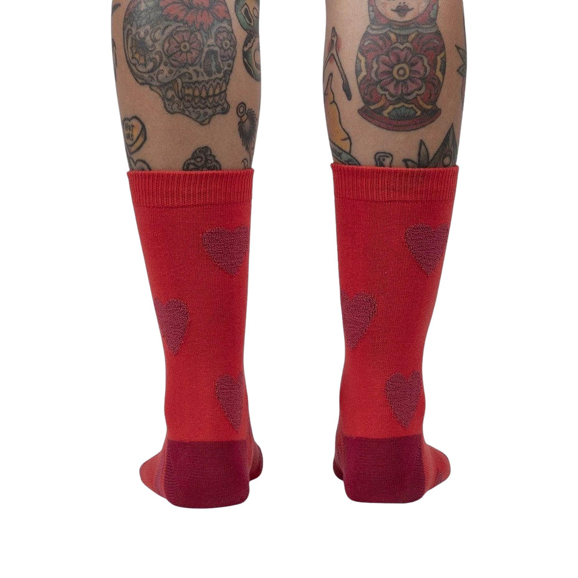 Back view of a person's legs wearing red crew socks with maroon fuzzy hearts.