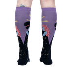 Rear view of model wearing a pair of Cosmic Connection knee-high socks.
