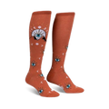 Pair of burnt orange knee-high socks with a repeating pattern of stylized eyes, moons, and celestial symbols.
