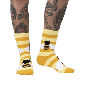 Lifestyle photo showing the Bee Cozy Slipper Socks on a person's legs.