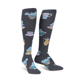 alt text: dark gray knee-high socks for women featuring a repeating pattern of cartoon manatees in pink, blue, and yellow tea party attire.  