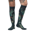 Lifestyle photo: Person wearing the Cactus Jungle knee-high socks, showing the socks on their legs.