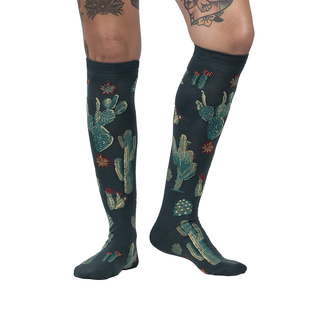 Lifestyle photo: Person wearing the Cactus Jungle knee-high socks, showing the socks on their legs.