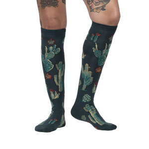 Lifestyle photo: Person wearing the Cactus Jungle knee-high socks, showing the socks on their legs.