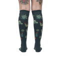 Back view of the Cactus Jungle knee-high socks on a person's legs, showing the design's full coverage.