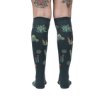 Back view of the Cactus Jungle knee-high socks on a person's legs, showing the design's full coverage.