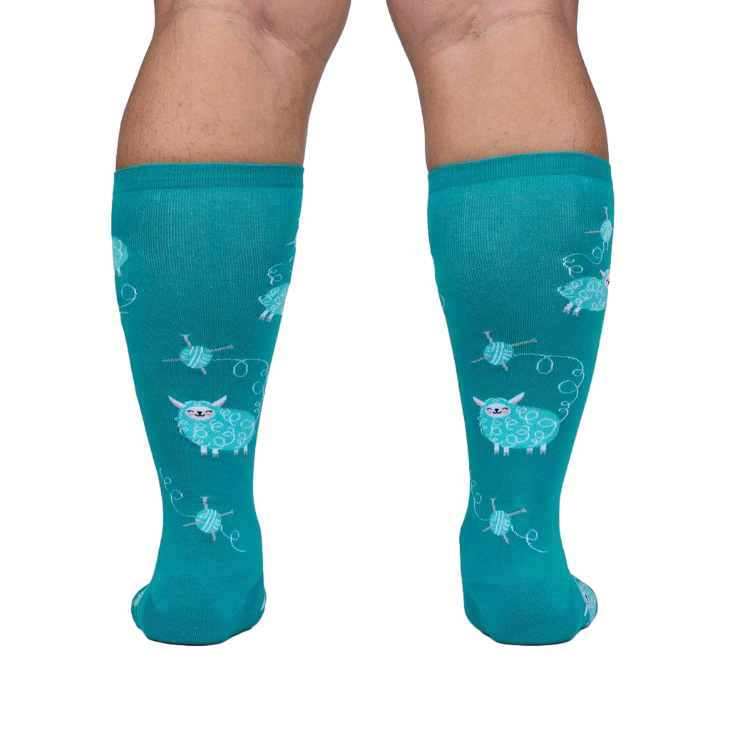 Rear view of teal sheep socks on a person's legs.
