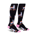 Pair of black knee-high socks with a repeating pattern of llamas wearing roller skates.  Accented with pink at the cuffs.