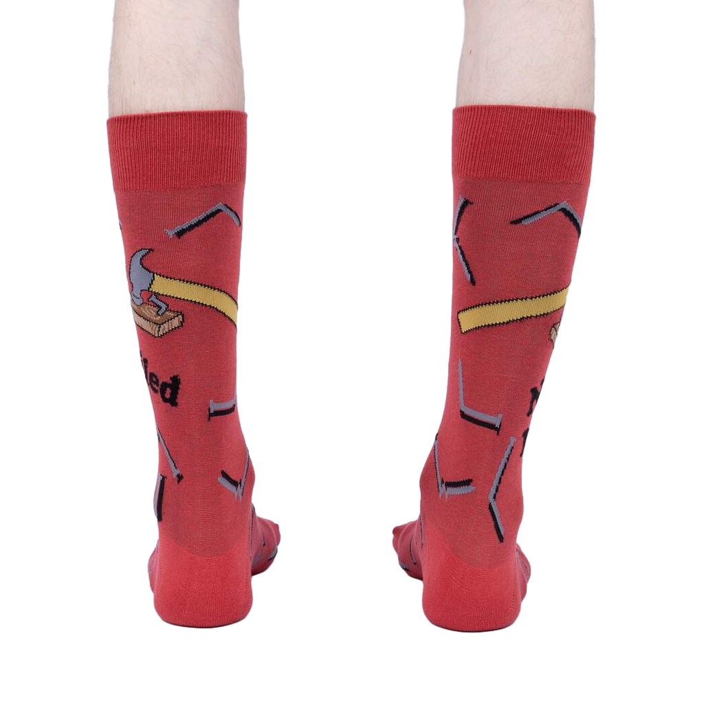 Rear view of the 'Nailed It' socks on a person, emphasizing the full design.