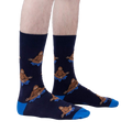Lifestyle shot showing the Meditating Bigfoot socks on a person's legs against a light grey background.