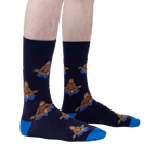 Lifestyle shot showing the Meditating Bigfoot socks on a person's legs against a light grey background.